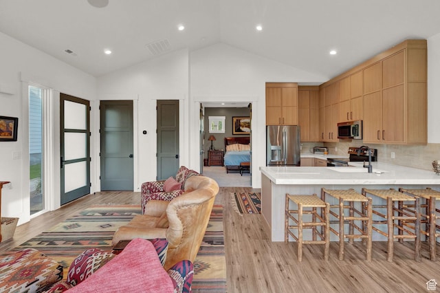 8122 S Willow Creek Cv, Cottonwood Heights, UT 84093 - kitchen with sink, light hardwood / wood-style floors, kitchen peninsula, and appliances with stainless steel finishes
