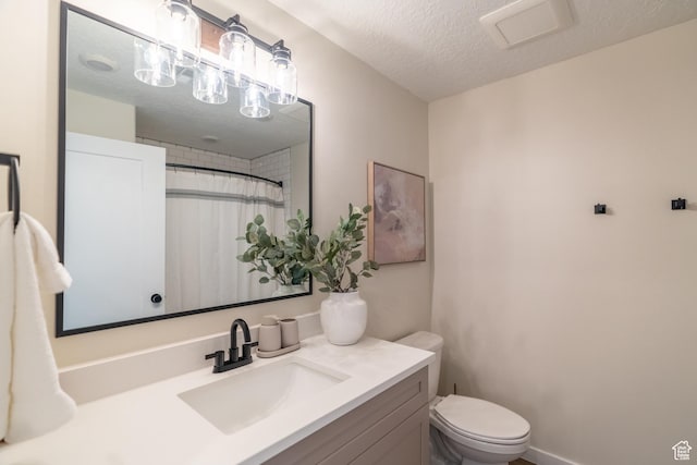 bathroom with vanity, curtained shower, toilet, and a textured ceiling