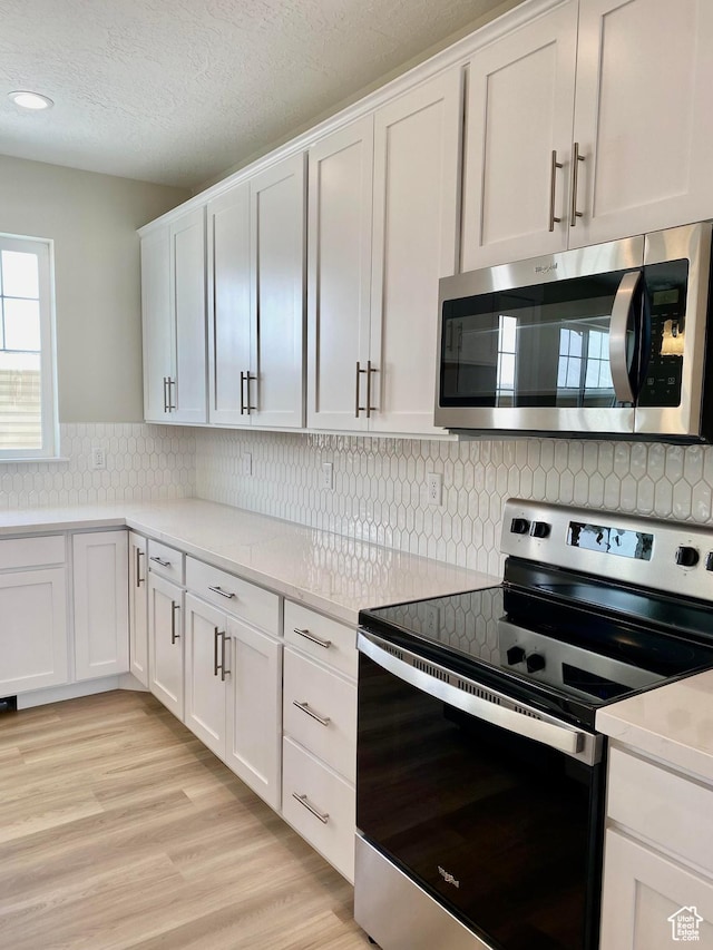 1688 N Centerpoint Ln, Salem, UT 84653 - kitchen with appliances with stainless steel finishes, light countertops, white cabinets, tasteful backsplash, and recessed lighting