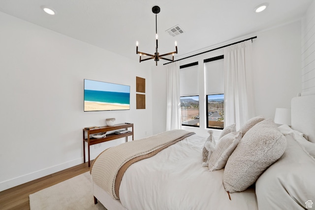 5466 S Persian Ln, St George, UT 84790 - bedroom featuring wood-type flooring and a notable chandelier