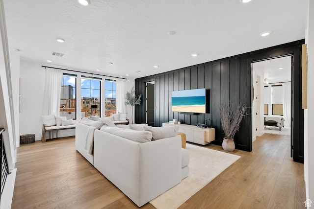 5466 S Persian Ln, St George, UT 84790 - living room with light hardwood / wood-style floors, a textured ceiling, and wooden walls
