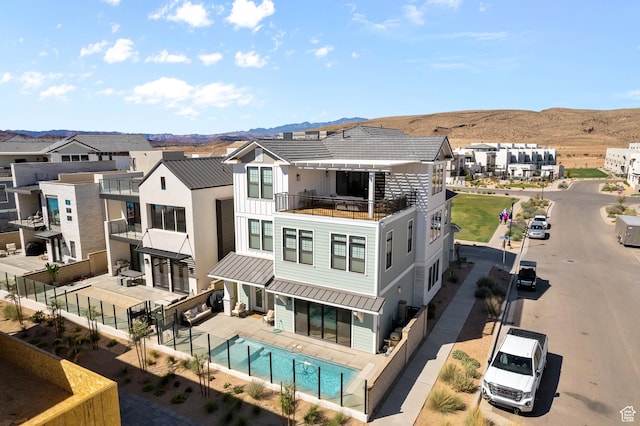 5466 S Persian Ln, St George, UT 84790 - rear view of house featuring a mountain view, a balcony, and a fenced in pool