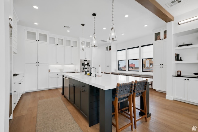 5466 S Persian Ln, St George, UT 84790 - kitchen with a large island with sink, white cabinetry, light hardwood / wood-style flooring, and pendant lighting