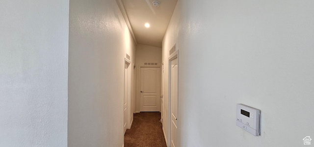 corridor featuring visible vents and dark carpet