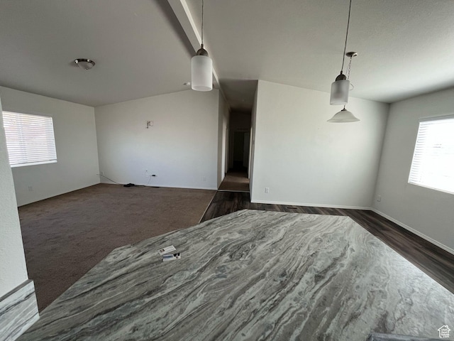 empty room with dark wood-style flooring and dark carpet