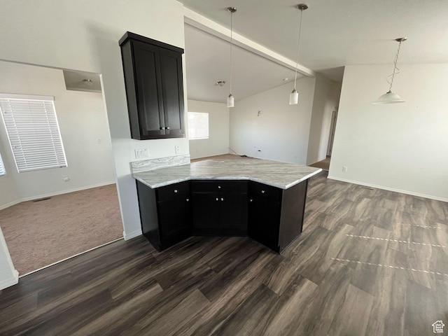kitchen featuring dark cabinets, lofted ceiling, a peninsula, and open floor plan