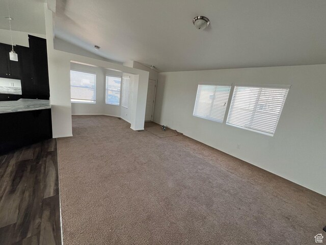 unfurnished living room with carpet and lofted ceiling