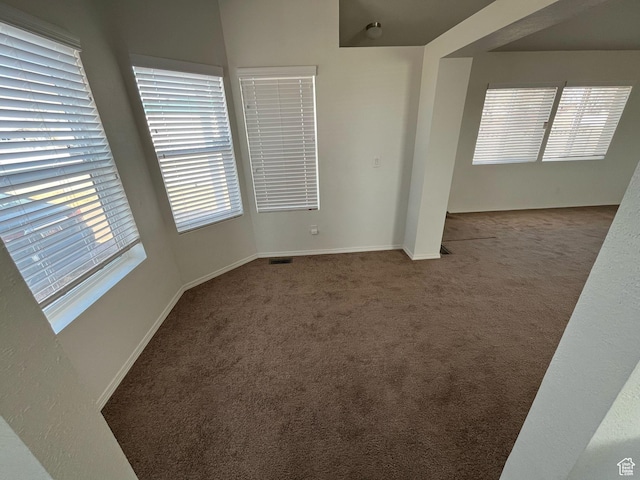 unfurnished room with visible vents, baseboards, and carpet