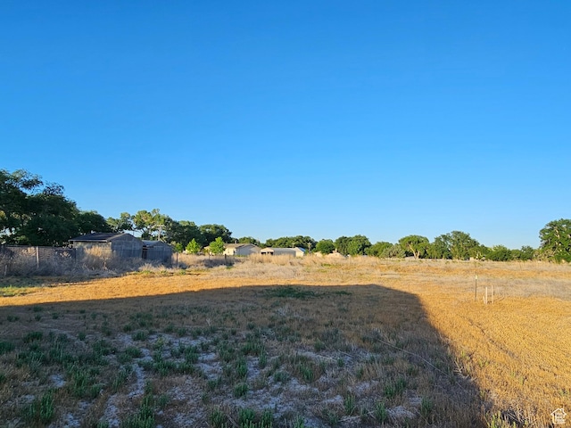 view of yard with a rural view and fence