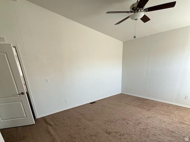 unfurnished room with dark colored carpet, visible vents, baseboards, and ceiling fan