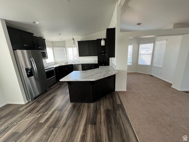 kitchen with dark wood finished floors, appliances with stainless steel finishes, dark cabinetry, and a peninsula