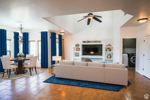 tiled living room with built in shelves, ceiling fan, and washing machine and dryer