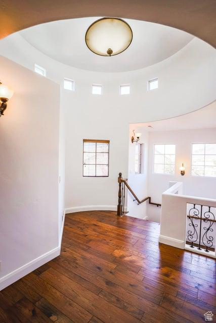 empty room featuring dark wood-type flooring and a high ceiling