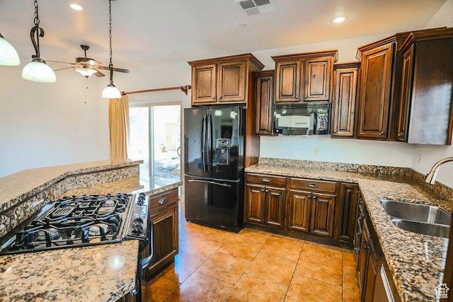 kitchen with sink, hanging light fixtures, light tile patterned floors, black appliances, and light stone countertops