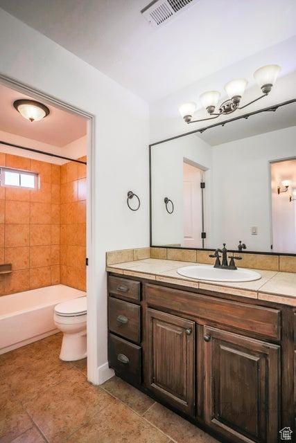 full bathroom featuring tiled shower / bath combo, vanity, and toilet