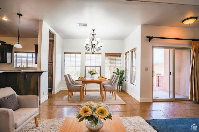 dining room featuring a healthy amount of sunlight, sink, and a notable chandelier