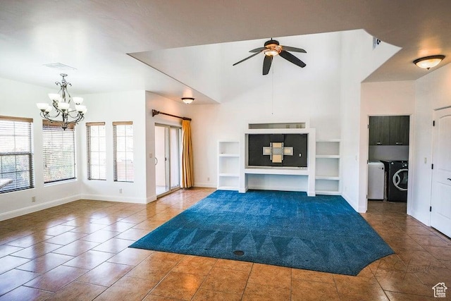 unfurnished living room with built in shelves, dark tile patterned floors, a towering ceiling, washer and clothes dryer, and ceiling fan with notable chandelier