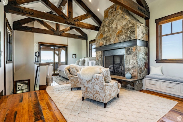 10454 E Forest Creek Rd, Kamas, UT 84036 - living area featuring wood finished floors, high vaulted ceiling, a stone fireplace, and beam ceiling