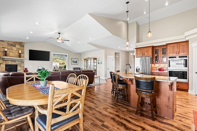 84 W 2100 N, Kamas, UT 84036 - dining space with a fireplace, lofted ceiling, ceiling fan, wood finished floors, and baseboards