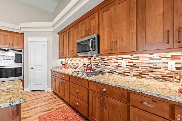 84 W 2100 N, Kamas, UT 84036 - kitchen with lofted ceiling, appliances with stainless steel finishes, backsplash, and brown cabinets