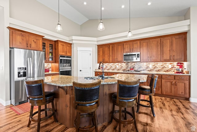 84 W 2100 N, Kamas, UT 84036 - kitchen with brown cabinetry, appliances with stainless steel finishes, light stone countertops, light wood-style floors, and a sink