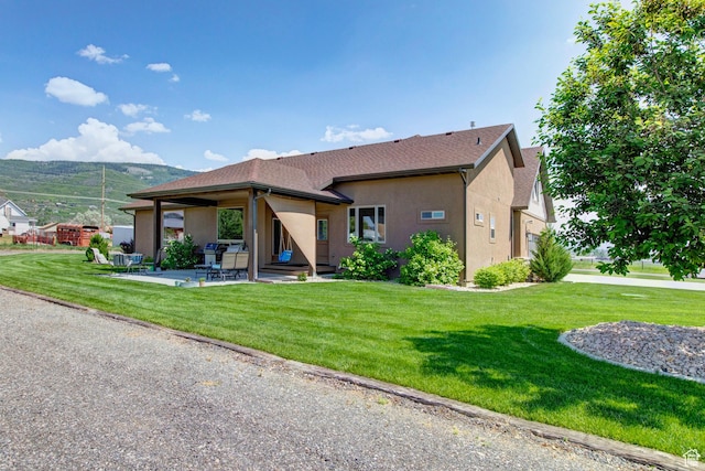 84 W 2100 N, Kamas, UT 84036 - view of front facade featuring a shingled roof, a patio area, a front lawn, and stucco siding