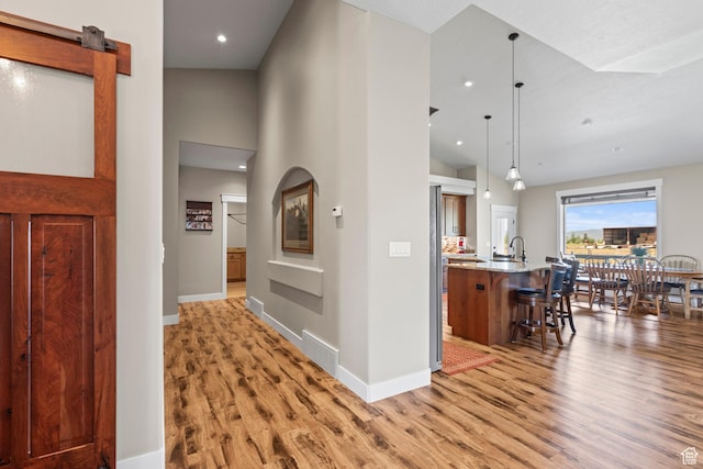 84 W 2100 N, Kamas, UT 84036 - hallway with light wood-type flooring, a barn door, high vaulted ceiling, and baseboards