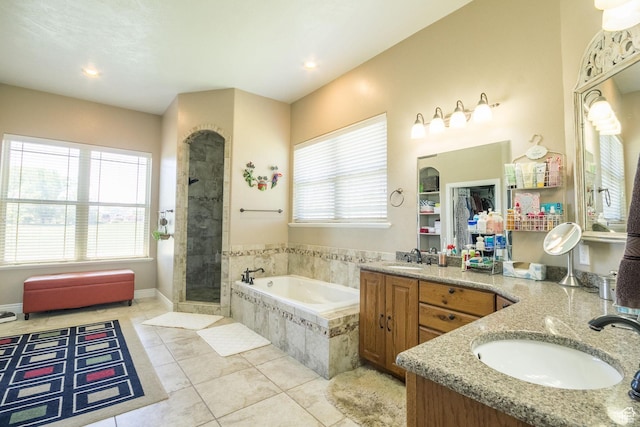bathroom featuring a bath, a tile shower, recessed lighting, vanity, and tile patterned flooring
