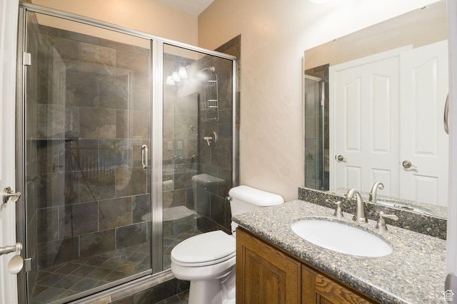 bathroom with a shower stall, vanity, and toilet