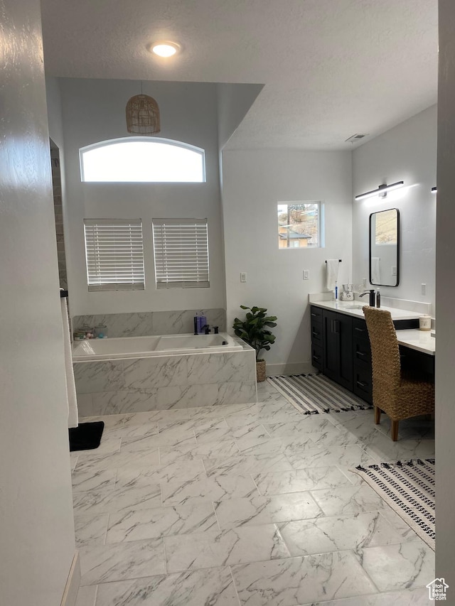40 E 200 N, Castle Dale, UT 84513 - bathroom featuring a textured ceiling, vanity, and tiled bath
