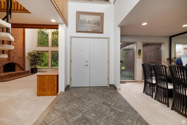 foyer with a brick fireplace and recessed lighting