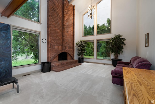 carpeted living area featuring high vaulted ceiling, an inviting chandelier, beamed ceiling, a fireplace, and visible vents