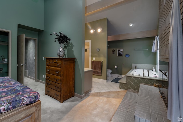 bathroom featuring tile patterned flooring, a towering ceiling, toilet, baseboards, and a garden tub