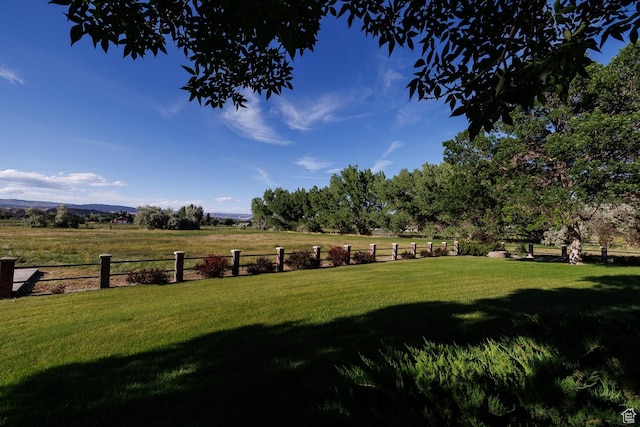 view of yard featuring fence and a rural view
