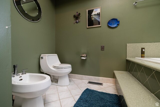 bathroom with tile patterned floors, baseboards, toilet, a bidet, and visible vents