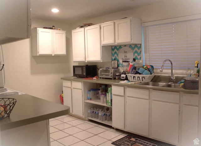 7642 S 2700 W, West Jordan, UT 84084 - kitchen featuring light tile patterned flooring, white cabinetry, sink, and tasteful backsplash