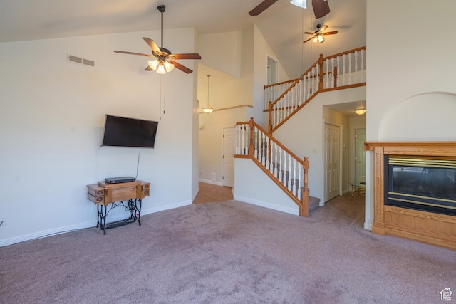 unfurnished living room with carpet, high vaulted ceiling, and ceiling fan