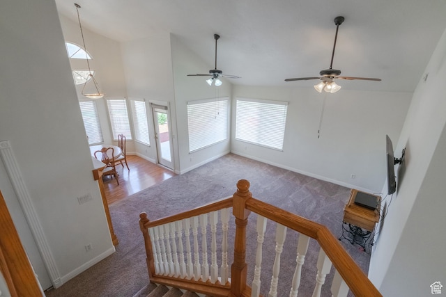 unfurnished living room with carpet floors, high vaulted ceiling, and ceiling fan