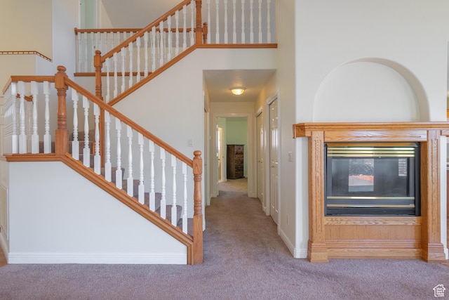 stairway with a towering ceiling and carpet