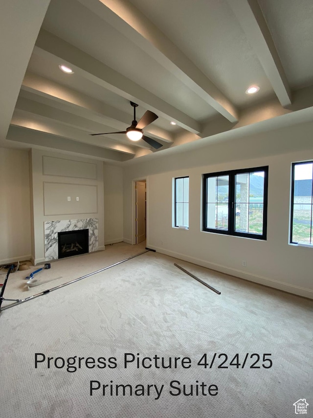 unfurnished living room featuring a fireplace, light carpet, beam ceiling, and baseboards