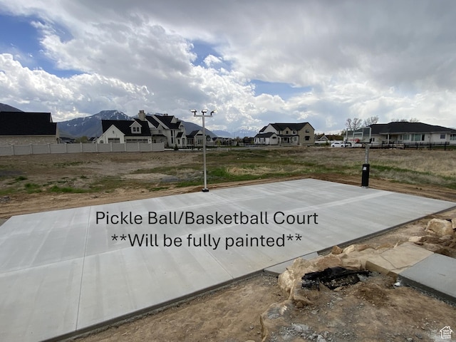 view of basketball court with fence and a residential view