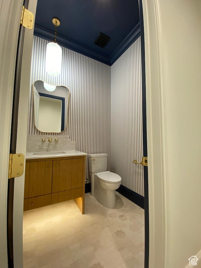 bathroom with crown molding, toilet, vanity, and tile patterned floors