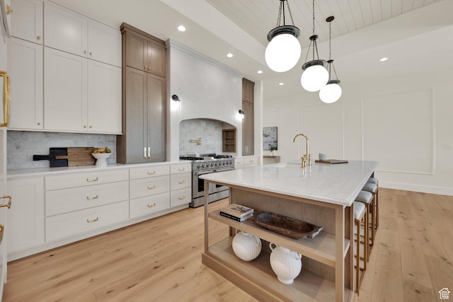 213 W 250 S Unit 15, Mapleton, UT 84664 - kitchen with high end stove, open shelves, a sink, backsplash, and light wood-style floors
