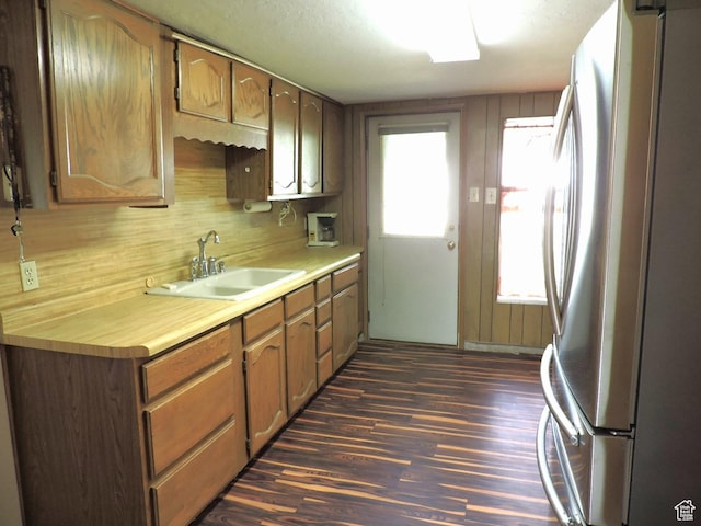 kitchen with stainless steel refrigerator, a wealth of natural light, sink, and dark hardwood / wood-style flooring