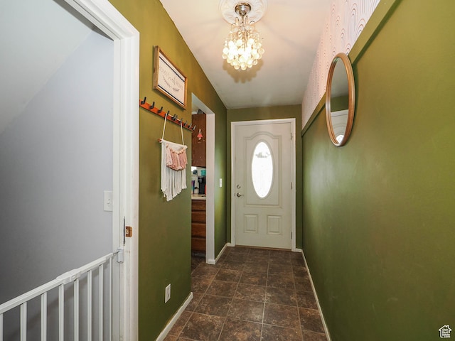 doorway to outside featuring a notable chandelier and dark tile floors