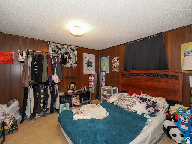 bedroom featuring wooden walls and a textured ceiling