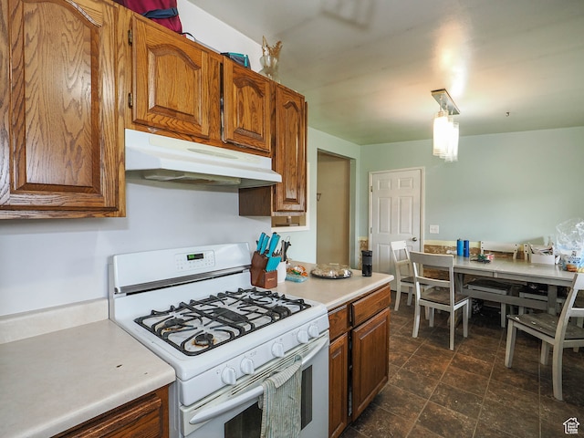 kitchen featuring white gas range oven and dark tile floors