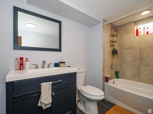 full bathroom featuring tiled shower / bath, vanity, toilet, and hardwood / wood-style floors