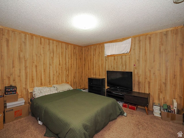 bedroom featuring a textured ceiling, carpet, and wood walls