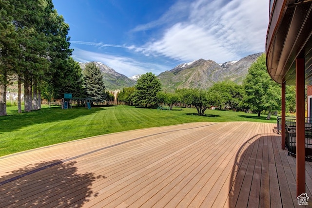wooden deck featuring a yard and a mountain view